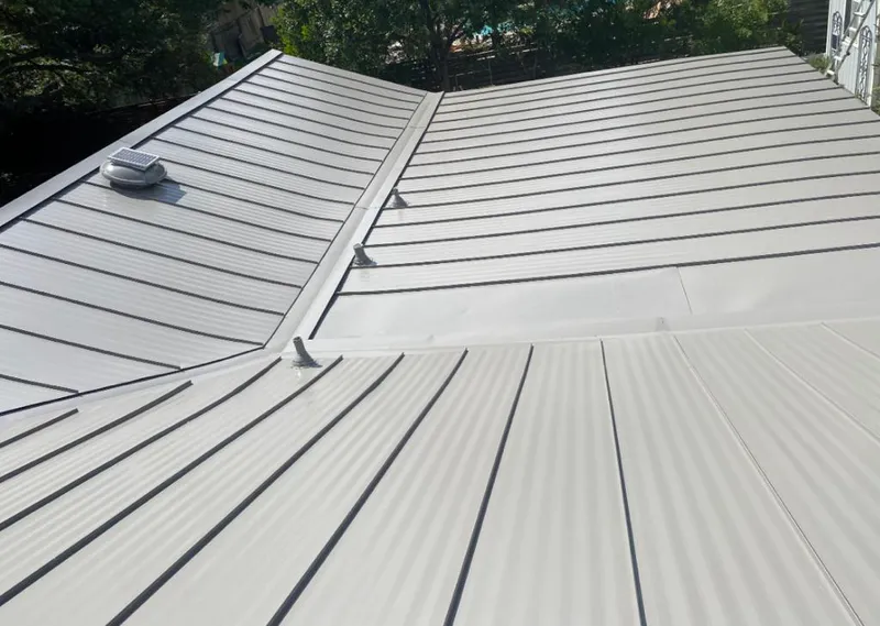 Solar attic fan installed on a metal roof for Roof Ventilation in August